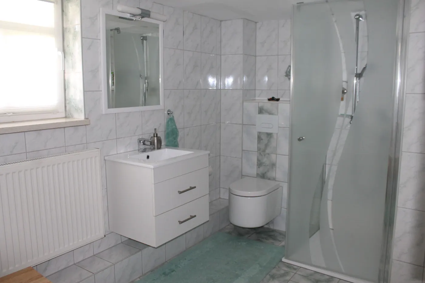 Badezimmer mit Dusche und Waschbecken
