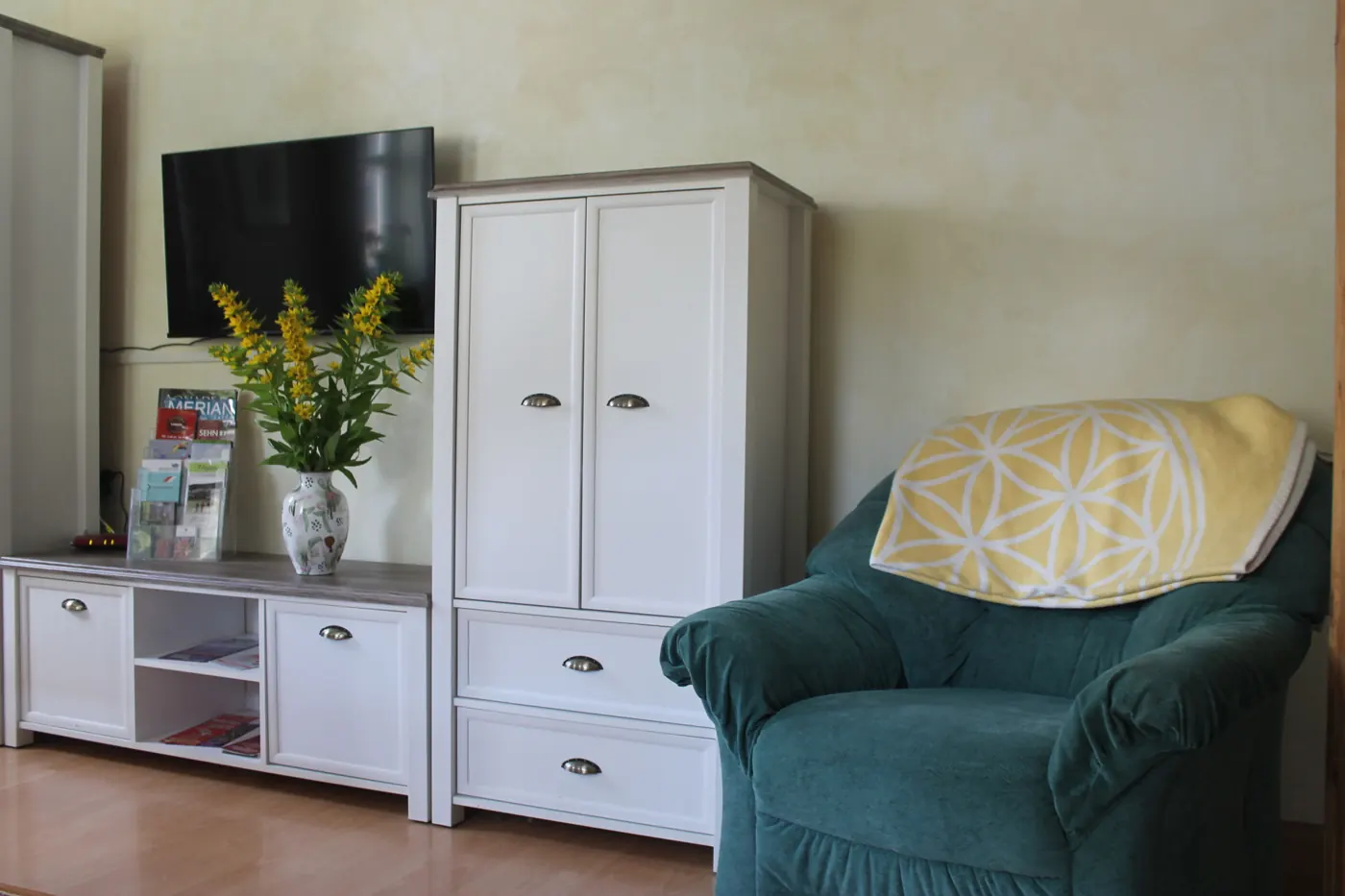 Wohnzimmer mit grünem Sofa und Schrank